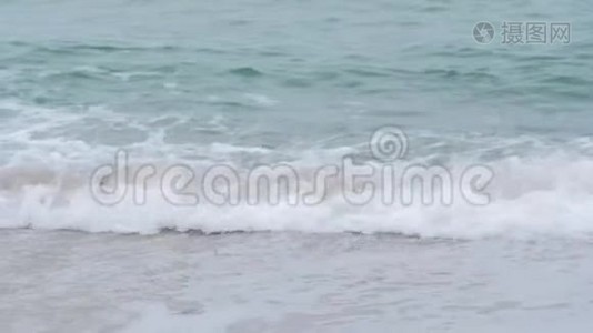 阴天时海浪拍打在沙滩上视频