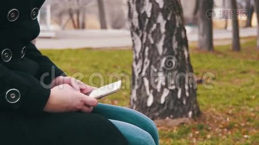 在城市公园的长凳上用手机的年轻女孩视频