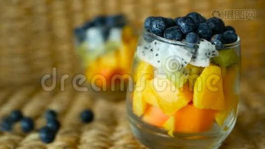 五颜六色的热带混合沙拉在罐子里。 玻璃碗中新鲜的各种生有机浆果和水果。 健康素食视频