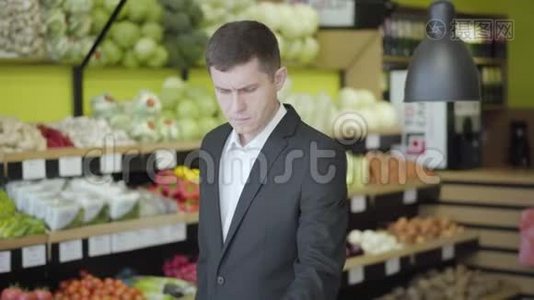中年白人在杂货店里选择柚子。 年轻自信的男人买健康的画像视频