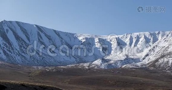 雪山顶上晶莹剔透的天空上太阳运动的时间推移。 秋天草地上的黄草。 无边无际视频