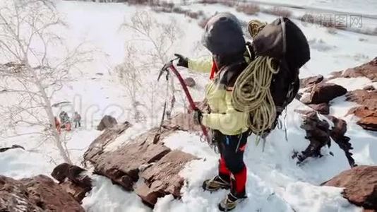 两个登山者爬上雪山的一个又大又陡的斜坡，拉着绳子往上爬视频