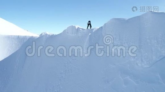 滑雪板在雪山山脊上的空中视野，准备骑下来。视频