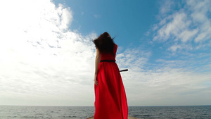 穿着红色长裙走在码头上的漂亮女人背影20秒视频
