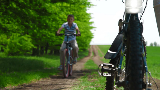 孩子骑自行车沿着乡间小路视频