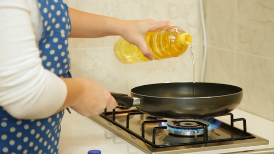 女人把橄榄油倒进煎锅里视频