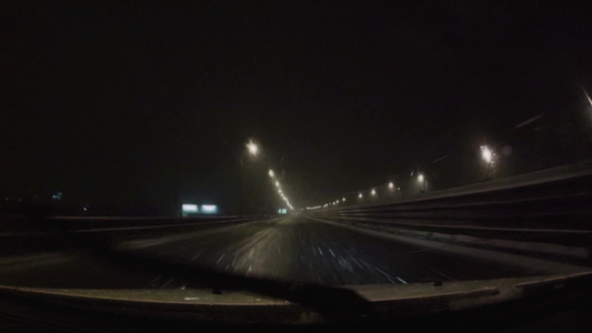 汽车在暴风雪中在夜间道路上行驶第一视角[受冷]视频