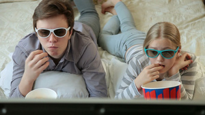 哥哥和姐姐在家吃爆米花和看3D电视电影28秒视频