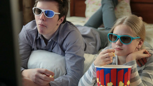 哥哥和姐姐在家吃爆米花和看3D电视电影25秒视频
