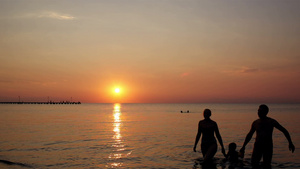 落日一家人在海滩上玩背影剪影17秒视频