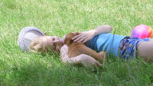 女孩抱着狗在草地上休息10秒视频
