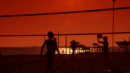 日落时孩子们在海滩上打排球视频