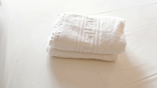 特写镜头的女性手，把两条白色干净的毛巾和橄榄枝放在床上视频