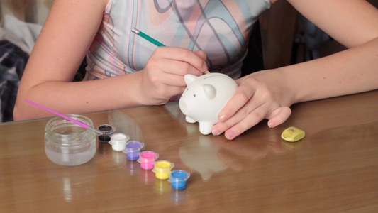 女孩在猪型存钱罐上色视频