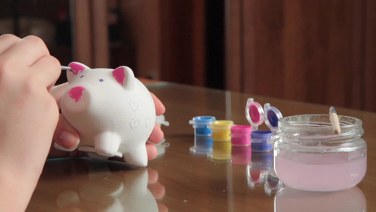 女孩画猪型存钱罐视频