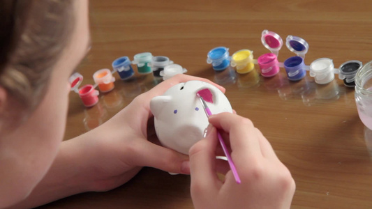 女孩画猪型存钱罐视频