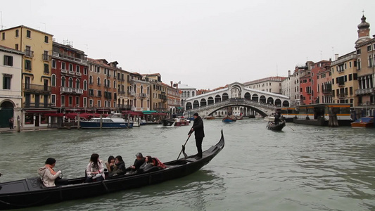 威尼斯河流上的载着游客的贡多拉船视频