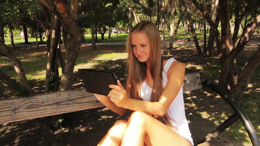 坐在长凳上使用平板电脑的女孩视频