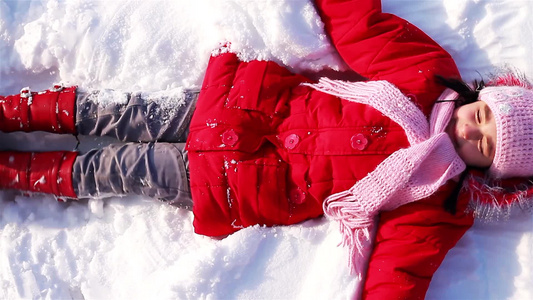 躺在雪地玩耍的小女孩视频