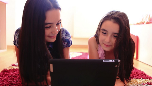 两个女孩看平板电脑视频