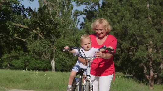 祖母和孙子在公园骑自行车玩得很开心视频