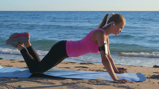 运动女孩在海滩上做俯卧撑视频