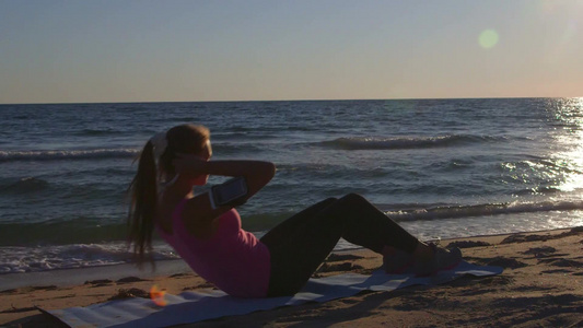 健身女性在海滩上仰卧起坐视频