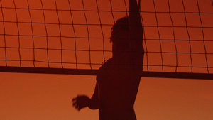 日落时在海滩上打排球的男人27秒视频