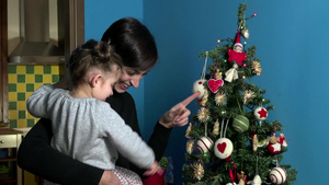 年轻妈妈抱着孩子看圣诞树16秒视频