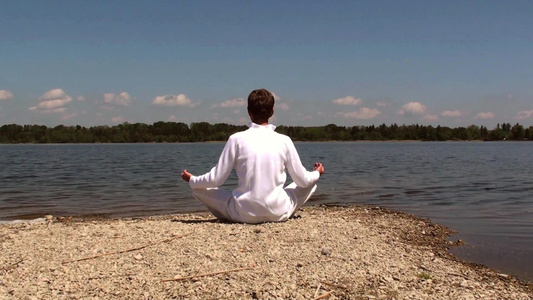 年轻男性湖泊岸边瑜伽冥想视频