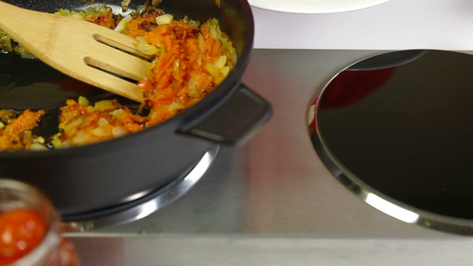 煎锅里烹饪的胡萝卜洋葱丁视频