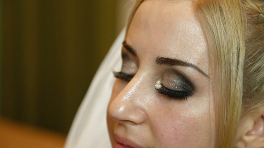 化妆师在给戴着头纱的新娘的画眼影视频