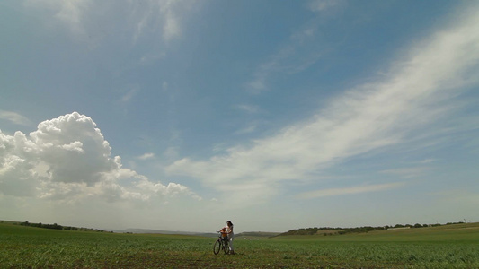 母亲和孩子骑自行车在田野里视频