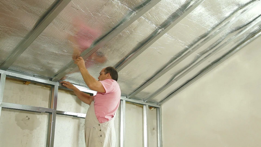 中年男性正在安装天花板架子视频