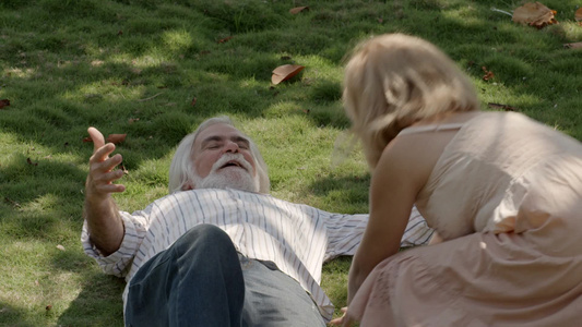 躺在公园的草地上的老年夫妻视频