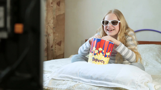 坐在床上看3D电影吃爆米花的女孩视频