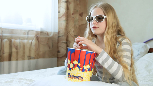 小金发女孩在家吃爆米花和看3D电影视频