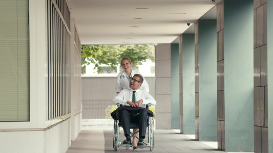 轮椅上的男性病人与医院的女医生交谈视频