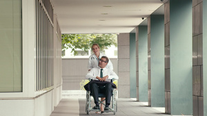 轮椅上的男性病人与医院的女医生交谈22秒视频