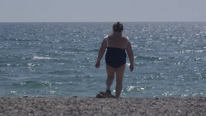 肥胖的妇女在沙滩上散步12秒视频