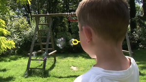小男孩在花园里吹泡泡12秒视频