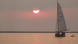 日落黄昏下海上漂泊的一艘帆船19秒视频