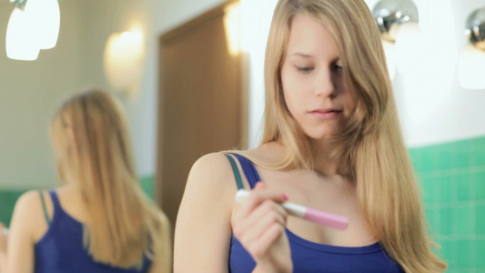 年轻妇女在家里的浴室里使用怀孕测试视频