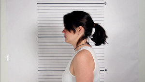 举着一张标语牌站在一堵白墙前的女罪犯照片20秒视频