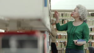 老年退休妇女在图书馆选书18秒视频