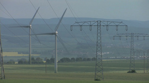 草地上的风力发电机和高压电线10秒视频