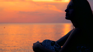 年轻的女人在海边的海滩上看日落27秒视频