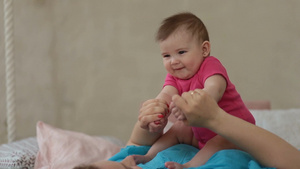 可爱的女婴在现代卧室里坐在母亲的胸前笑的肖像13秒视频