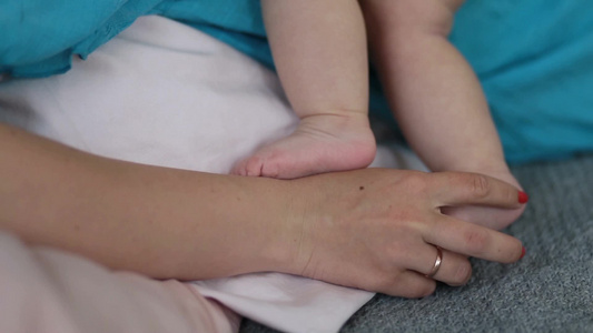 母亲的手抚摸小婴儿脚特写视频