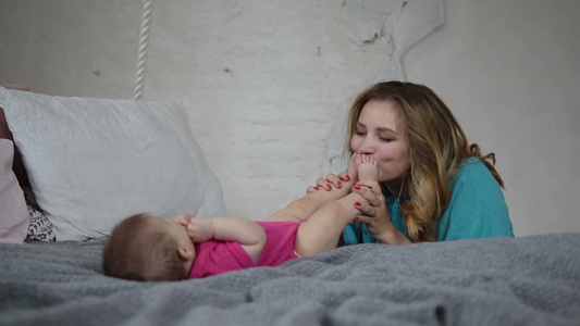 年轻女性亲吻婴儿的脚丫视频